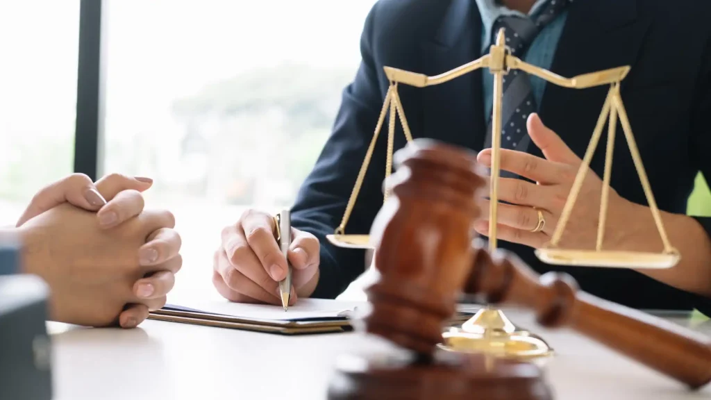 Lawyer discussing legal matters with a gavel and scales of justice on the table.