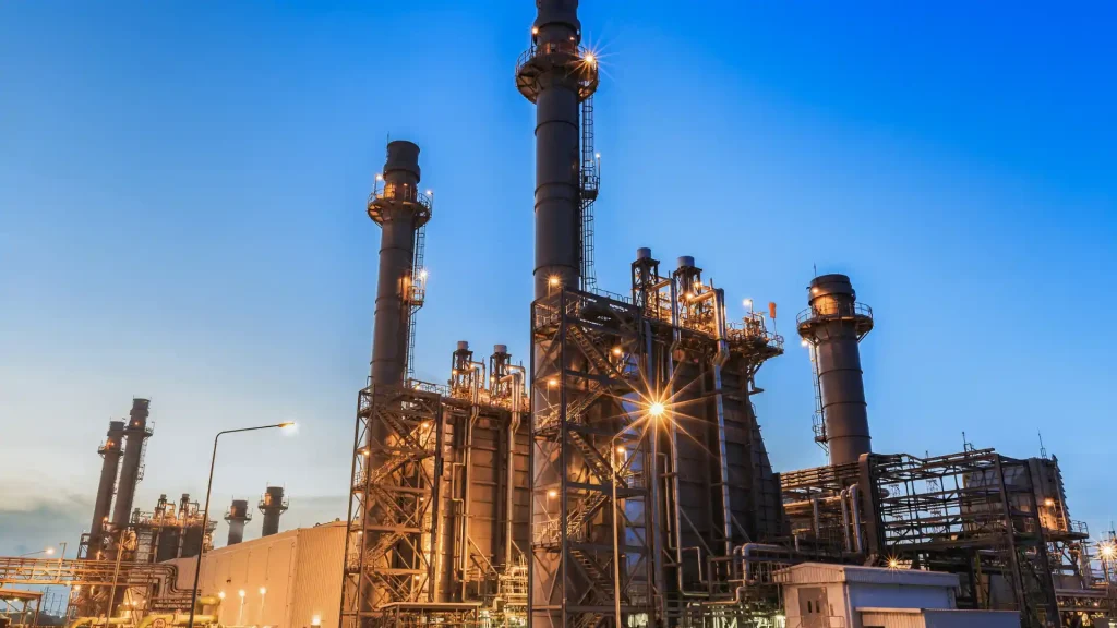Illuminated refinery towers at twilight